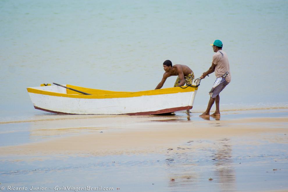 Imagem de dois pescadores empurrando mar para mar Praia Corumbau.